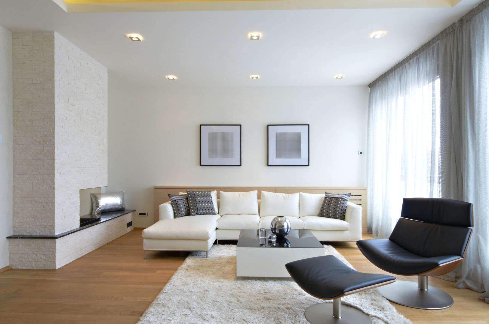 Wohnzimmer mit weißem Sofa und modernem Kamin